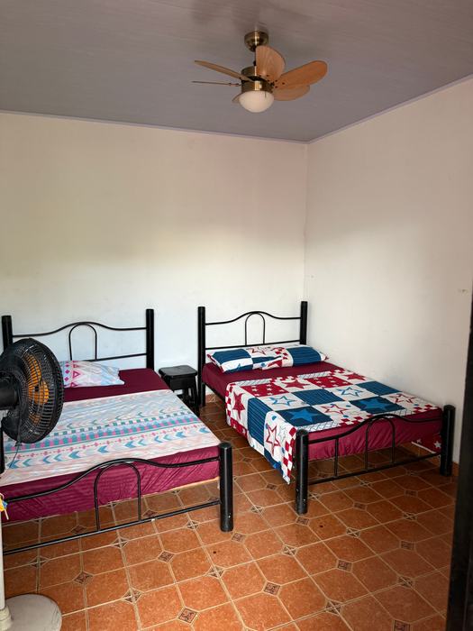 Habitación con dos camas dobles y ventilador de techo